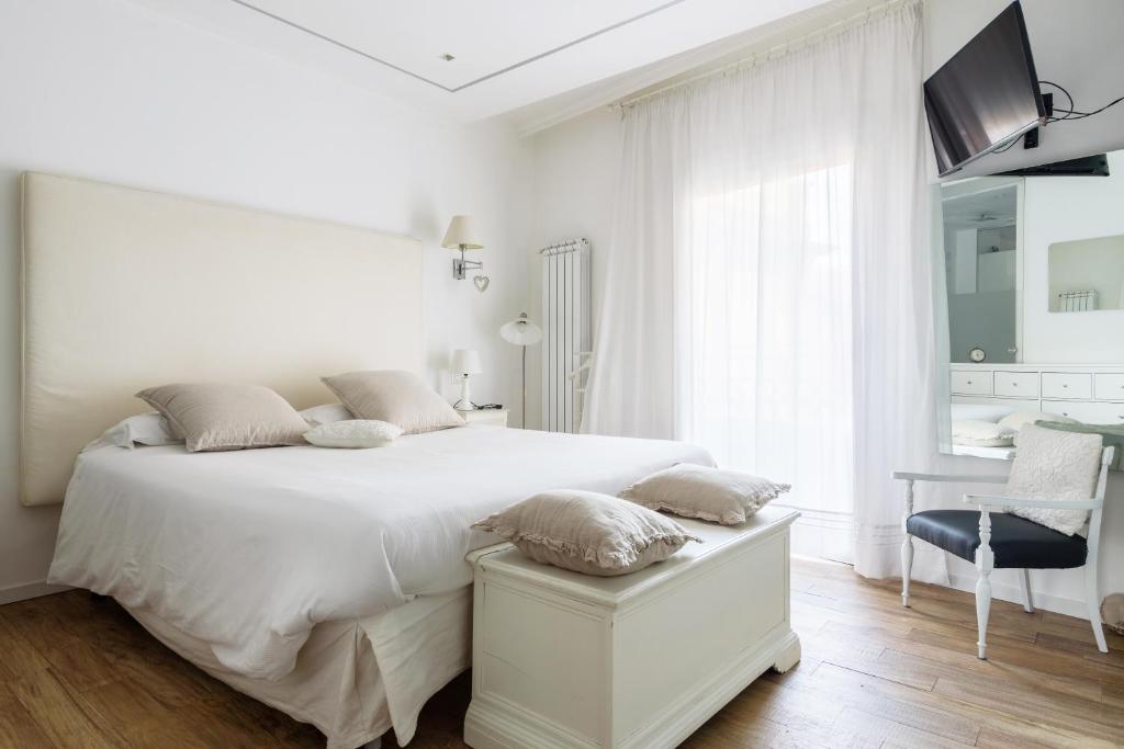 a white bedroom with a white bed and a desk at Luxury modern one bedroom in great location in Milan