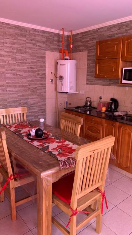 a kitchen with a wooden table with chairs and a kitchen at Lavanda 1 in El Calafate