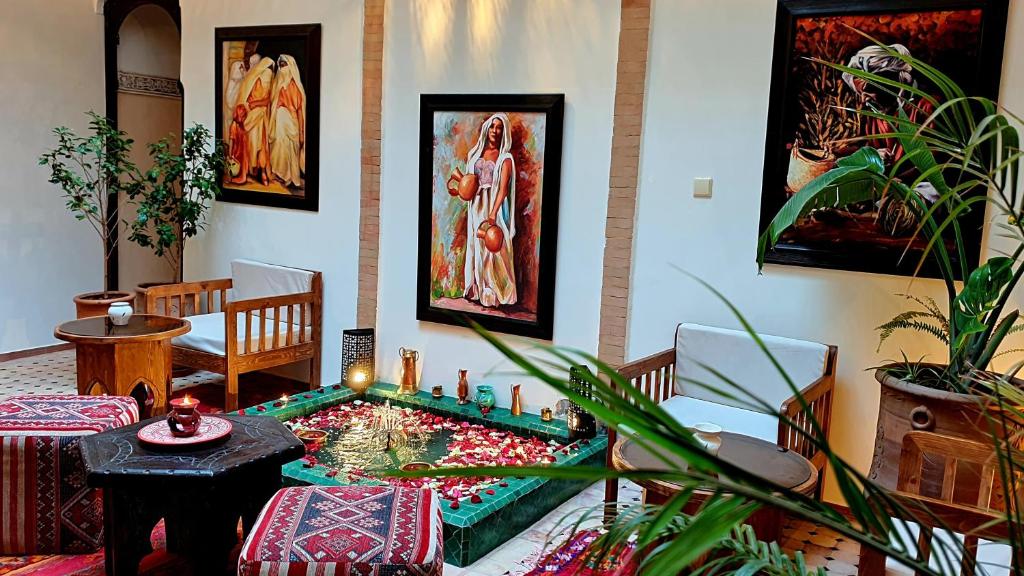 Ein Zimmer mit einem Wohnzimmer mit einem Tisch und einem Raum mit Aktivitäten in der Unterkunft Dar Salam - All Inclusive - 2023 Best Hospitality Award in Marrakesch