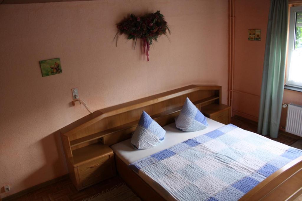 a bedroom with a bed with two pillows on it at Mühlbachhof in Berg