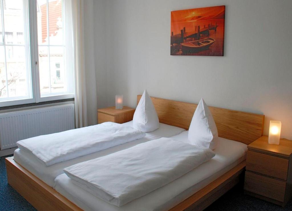 ein Schlafzimmer mit einem Bett mit weißer Bettwäsche und zwei Kerzen in der Unterkunft Zentrale Ferienwohnung 51qm im Hotel zur Börse in Hameln