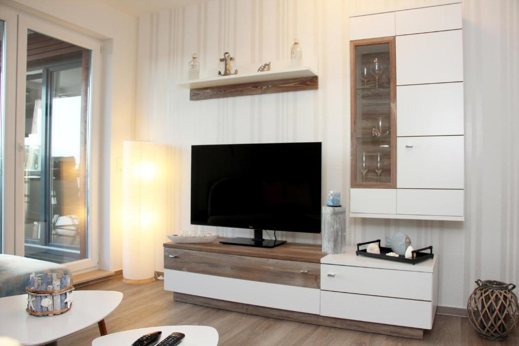 a living room with a flat screen tv on a cabinet at Ostseebrise in Brenkenhagen