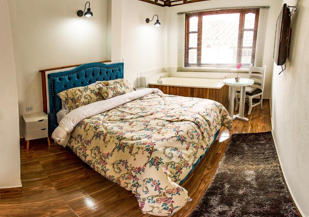 una camera da letto con un letto grande con testiera blu di Hotel Bahía Olivo Boutique & Spa a Villa de Leyva