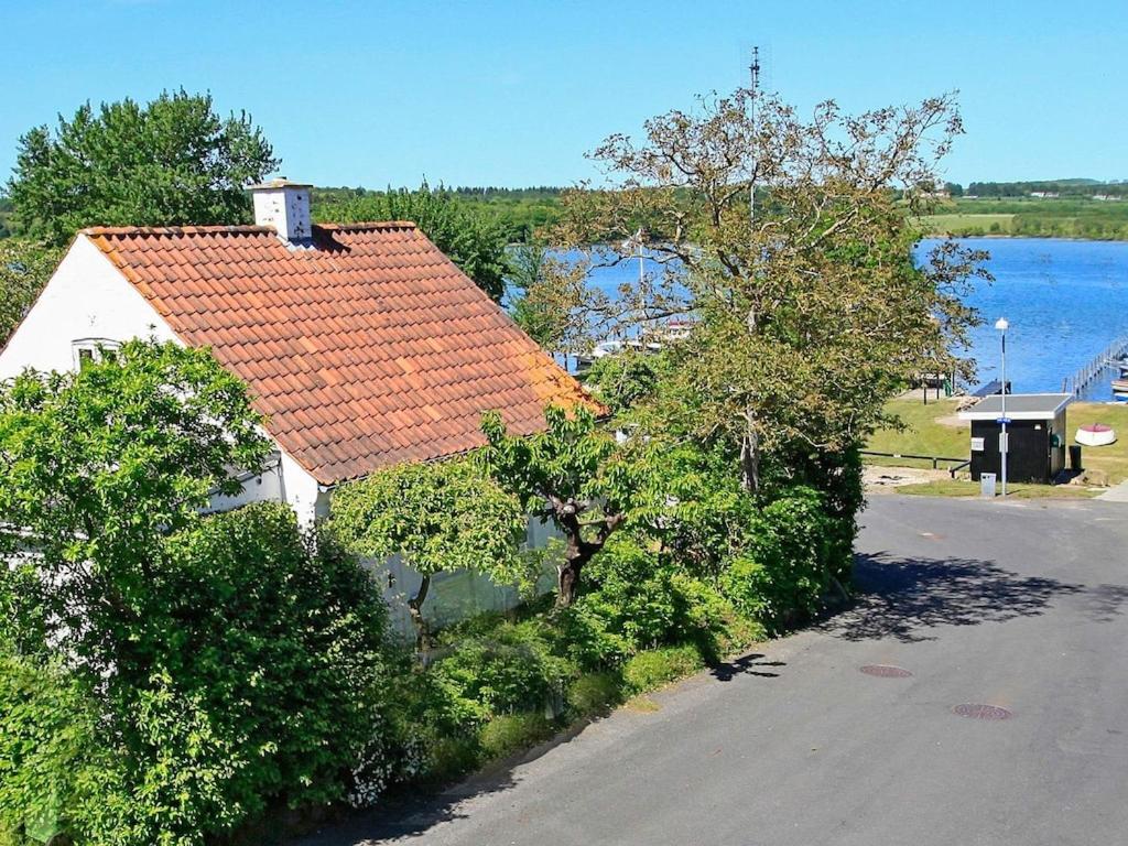 een huis met een oranje dak naast een straat bij Two-Bedroom Holiday home in Svendborg 3 in Svendborg