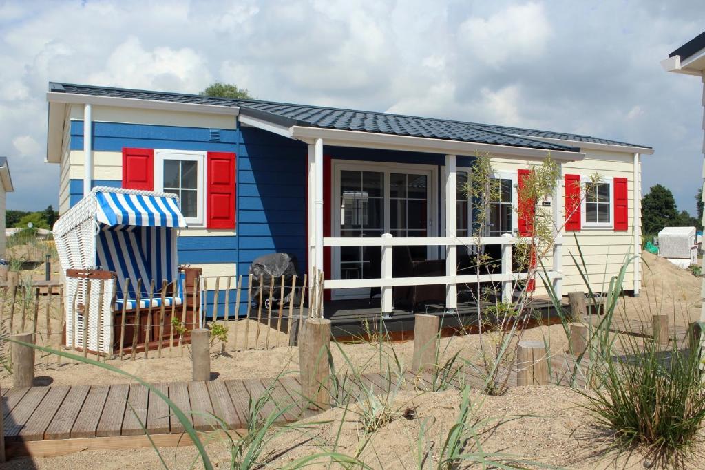 uma pequena casa azul e branca na praia em Strand 5 em Scharbeutz
