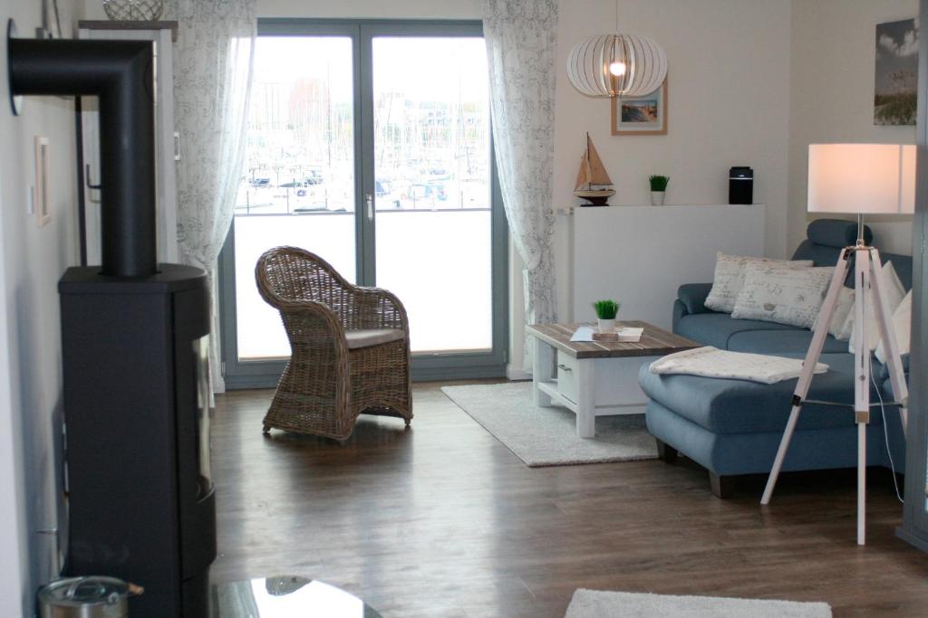 ハイリゲンハーフェンにあるOstsee - Appartement Nr 95 "Möwe" im Strand Resortのリビングルーム(青いソファ、椅子付)