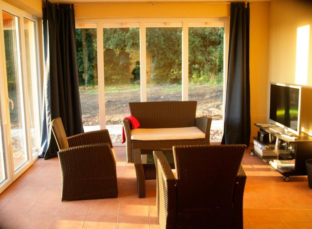een woonkamer met een tafel en stoelen en een televisie bij Souhayla in Friedenstal