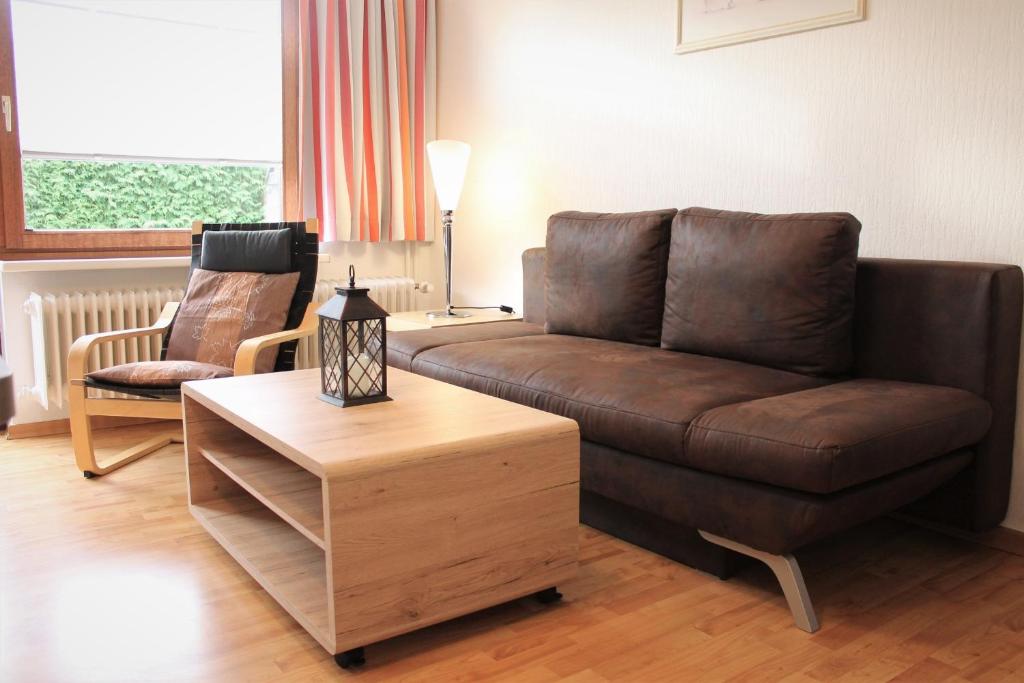 格洛米茨的住宿－"Wohnung 1 - G Pape" mit 2 Terrassen, kostenloses WLAN, Longstay Rabatt, Nähe Dünenpark，客厅配有棕色沙发和桌子