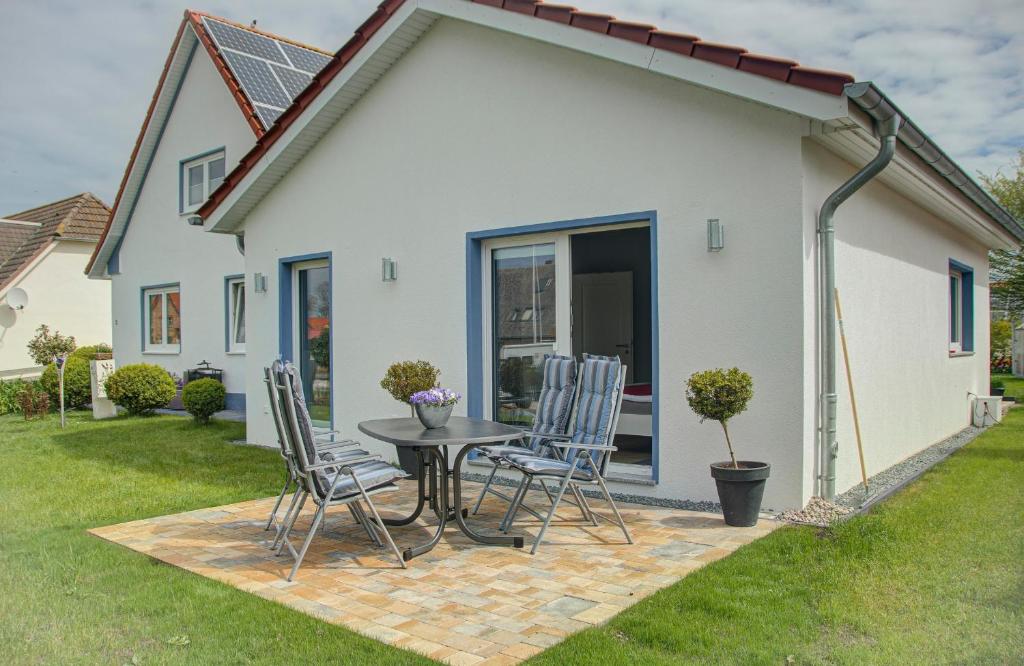 un patio con sillas y una mesa frente a una casa en Ferienhaus Sewald en Wulfen auf Fehmarn