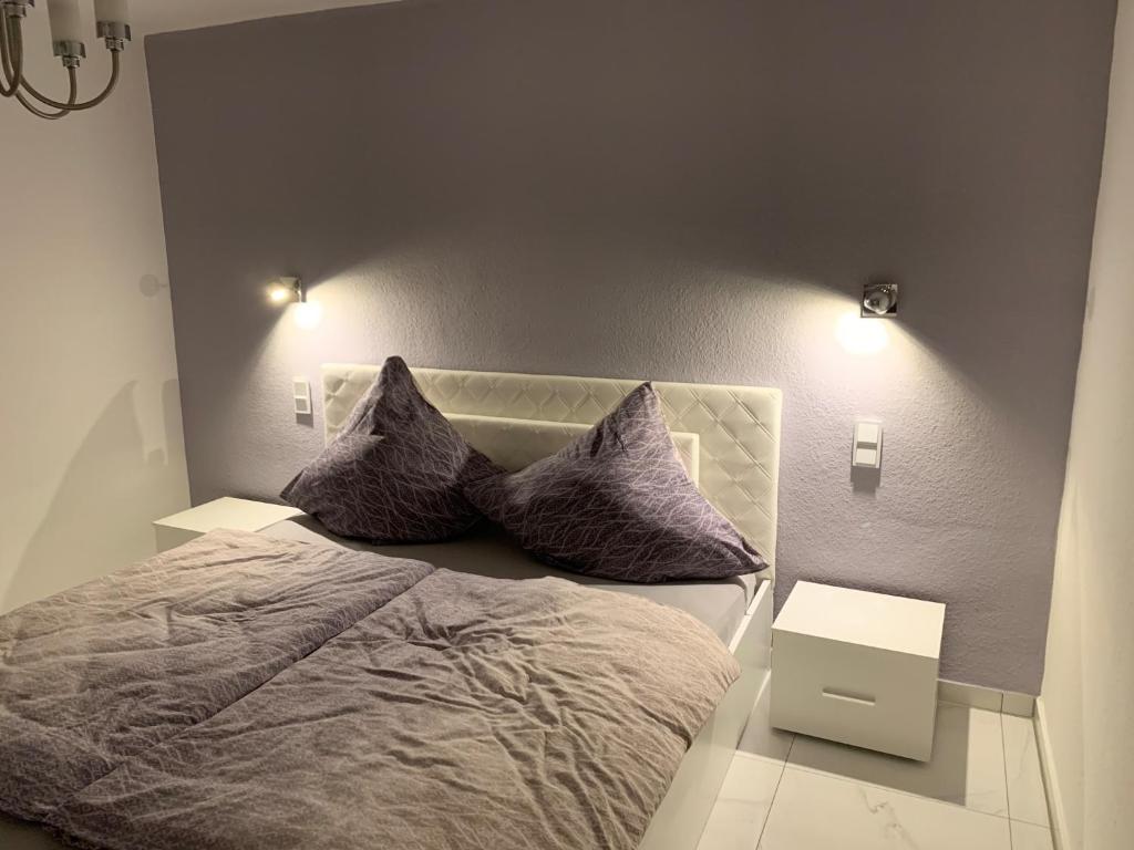 Moderne 2 Zimmer Wohnung mit Vollausstattung في Ketsch: غرفة نوم عليها سرير ووسادتين