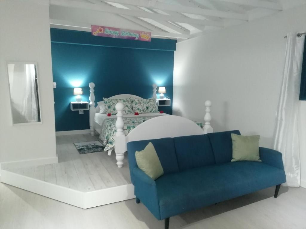 a blue and white bedroom with a bed and a couch at Casa del Vega a Little Peace of Heaven in Castries