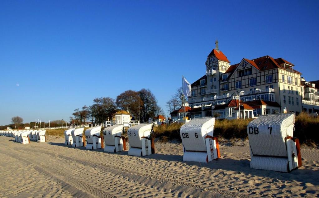 uma fila de máquinas de praia na areia perto de um edifício em MeeresBlick Urlaubstraum an der Ostsee em Kühlungsborn