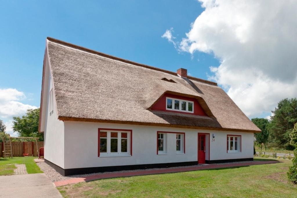 a white house with a brown roof at Ferienhaushälfte Hanna in Wieck