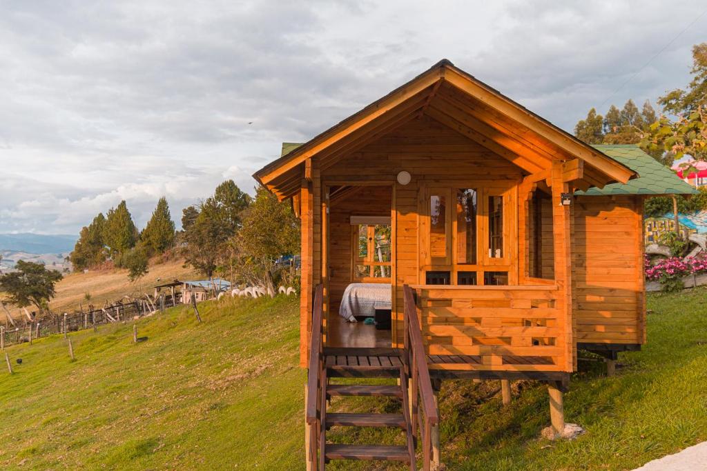 a small wooden house on a hill with a ladder at Refugio de Guacheneque, Glamping y Hospedaje Rural in Villapinzón
