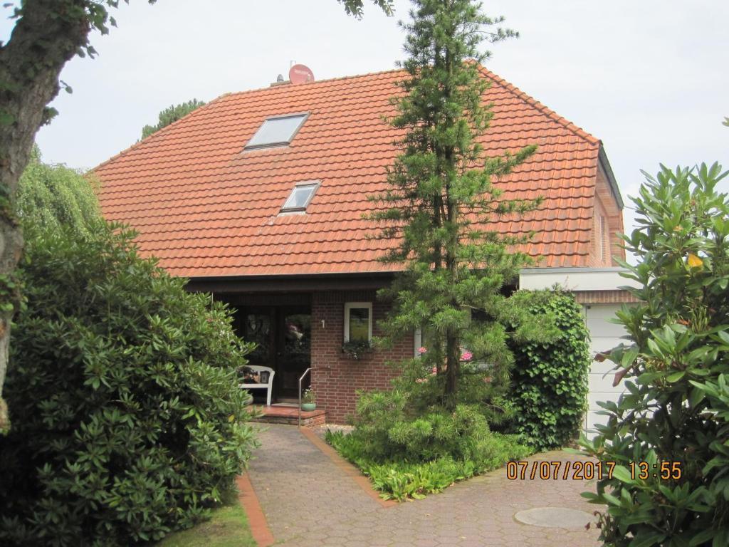 パーペンブルクにあるFerienwohnung Marimのパティオ付きのオレンジ色の屋根のレンガ造りの家