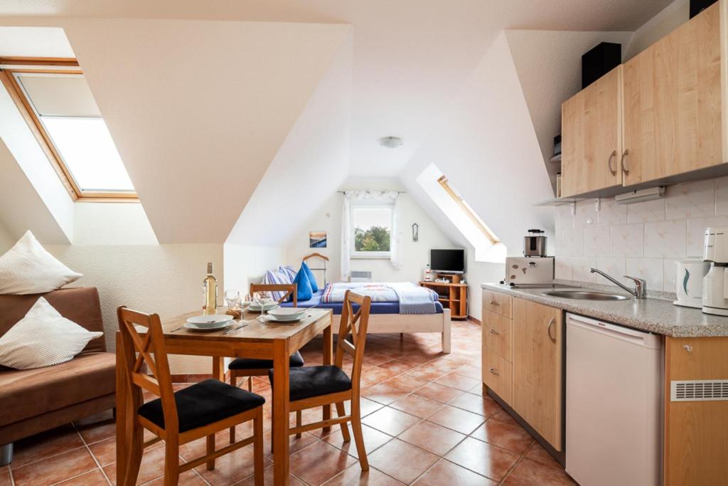 cocina y sala de estar con mesa y sillas en Ostsee-Schwänchen II en Gollwitz
