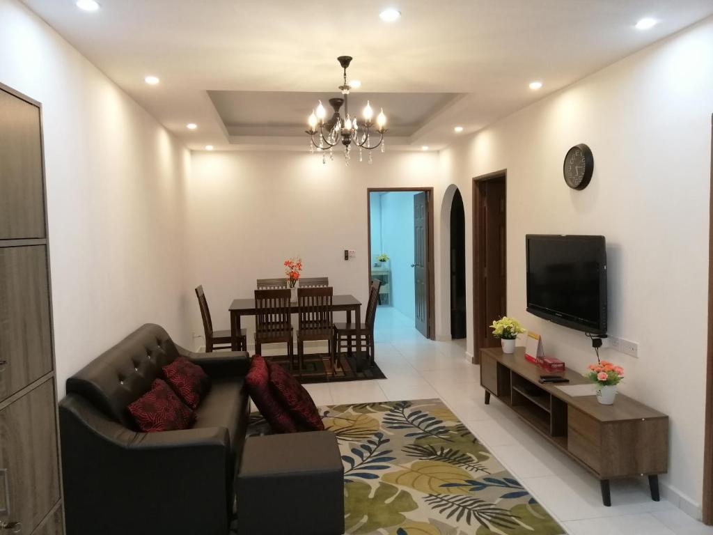 a living room with a couch and a tv at Onies Homestay Lumut Manjung in Lumut