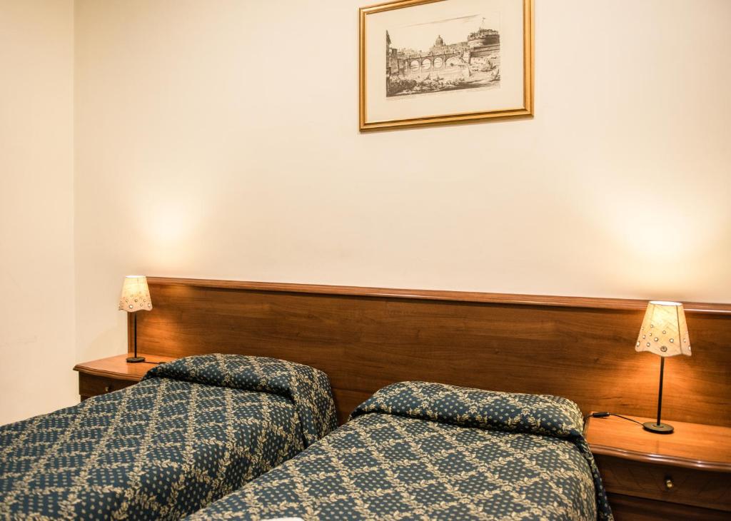 pokój hotelowy z łóżkiem i 2 lampami w obiekcie Alloggio Turistico w Rzymie