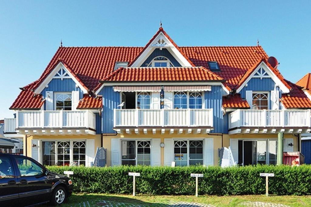 une maison avec un toit rouge et une voiture garée devant dans l'établissement Villa Vogelsang, FW 2, à Zingst