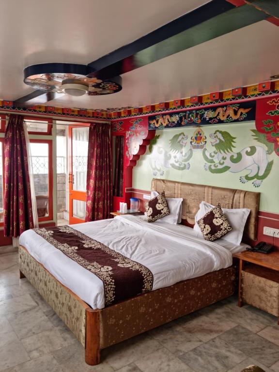 a bedroom with a large bed and a wall with a painting at hotel Seven Seventeen in Darjeeling