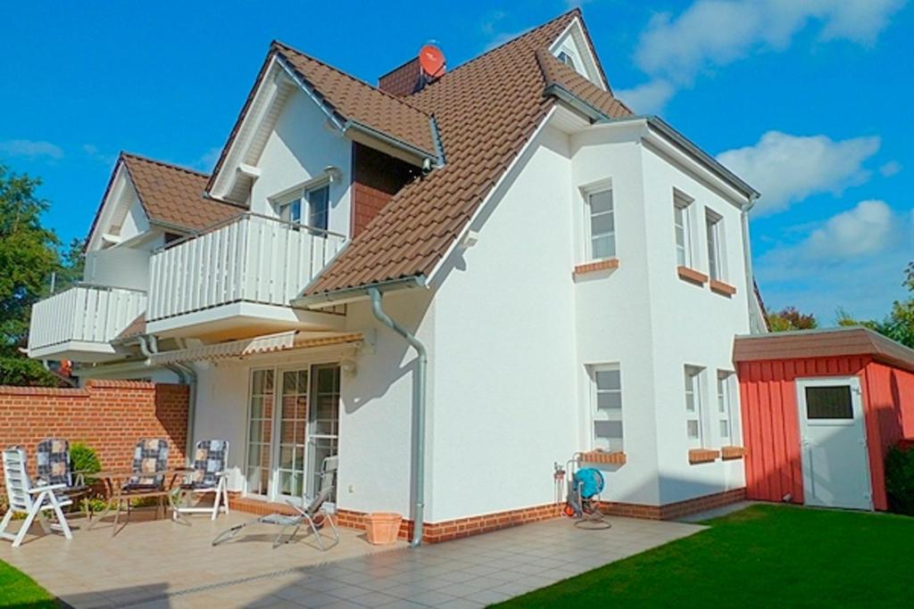 een wit huis met een dak en een patio bij Sonnenpalais in Zingst
