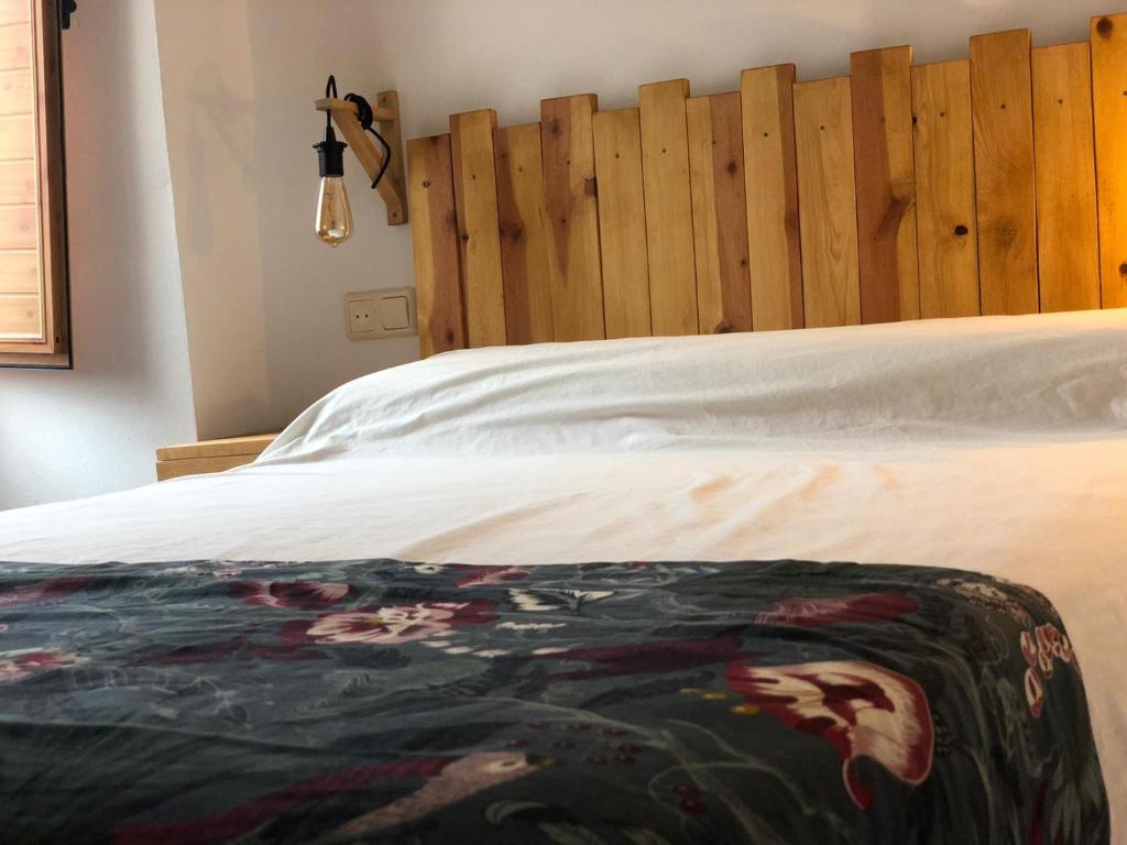 a bedroom with a bed with a wooden headboard at vtar la veguilla in Polvillar