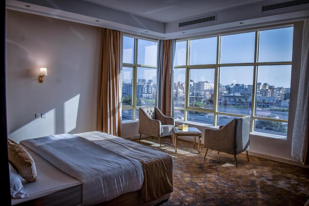 um quarto de hotel com uma cama e uma grande janela em درة العروس للوحدات السكنية المفروشة em Jidá
