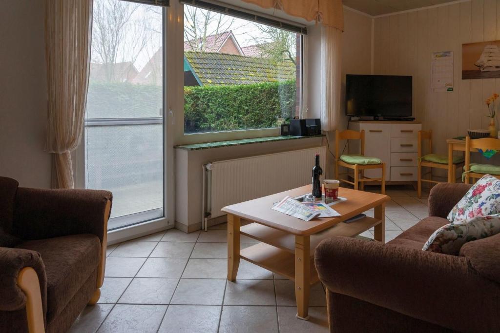 ヴェルドゥムにあるFerienwohnung SMUTJE in Werdumのリビングルーム(ソファ、テーブル付)、窓が備わります。