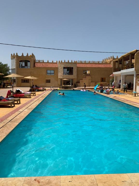 une grande piscine d'eau bleue devant un bâtiment dans l'établissement Al Kasbah, à El Jadida