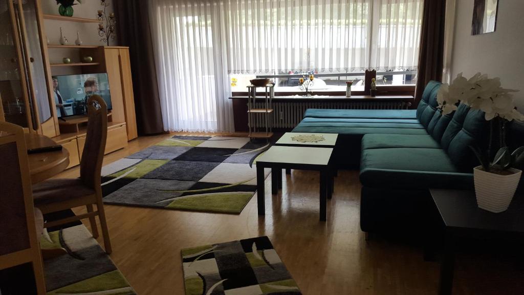 a living room with a green couch and a table at Ferienwohnung Waldblick in Schluchsee