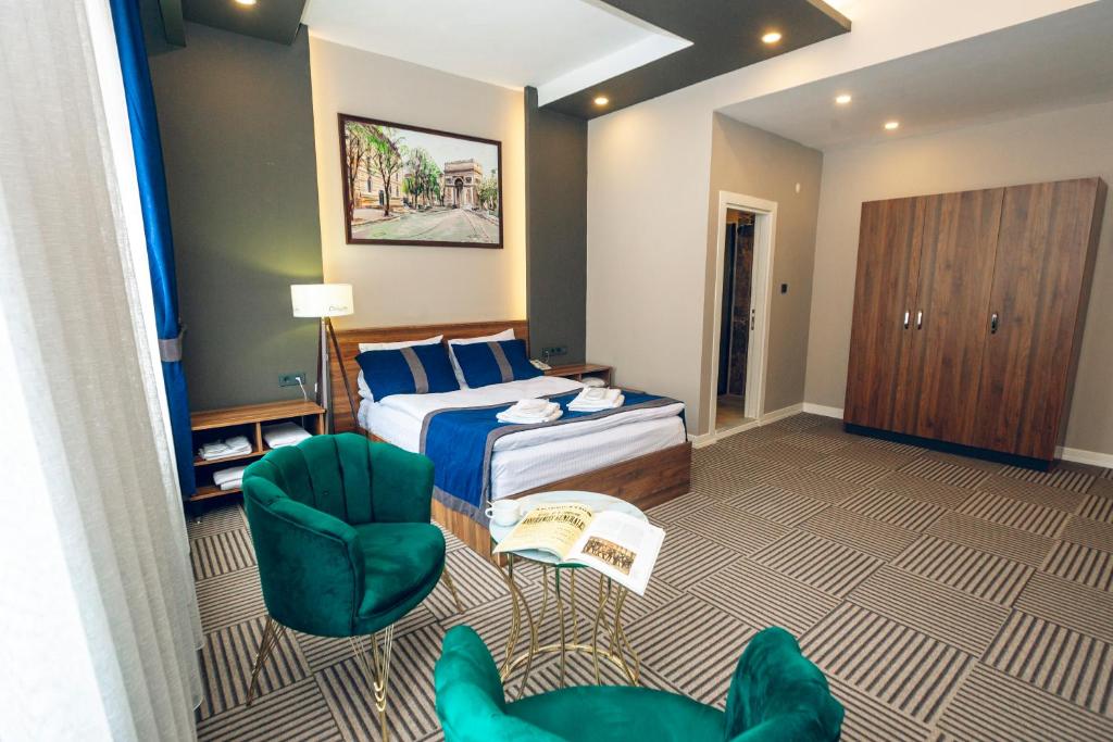une chambre d'hôtel avec un lit et deux chaises dans l'établissement Grand Catalkaya Hotel, à Erzurum