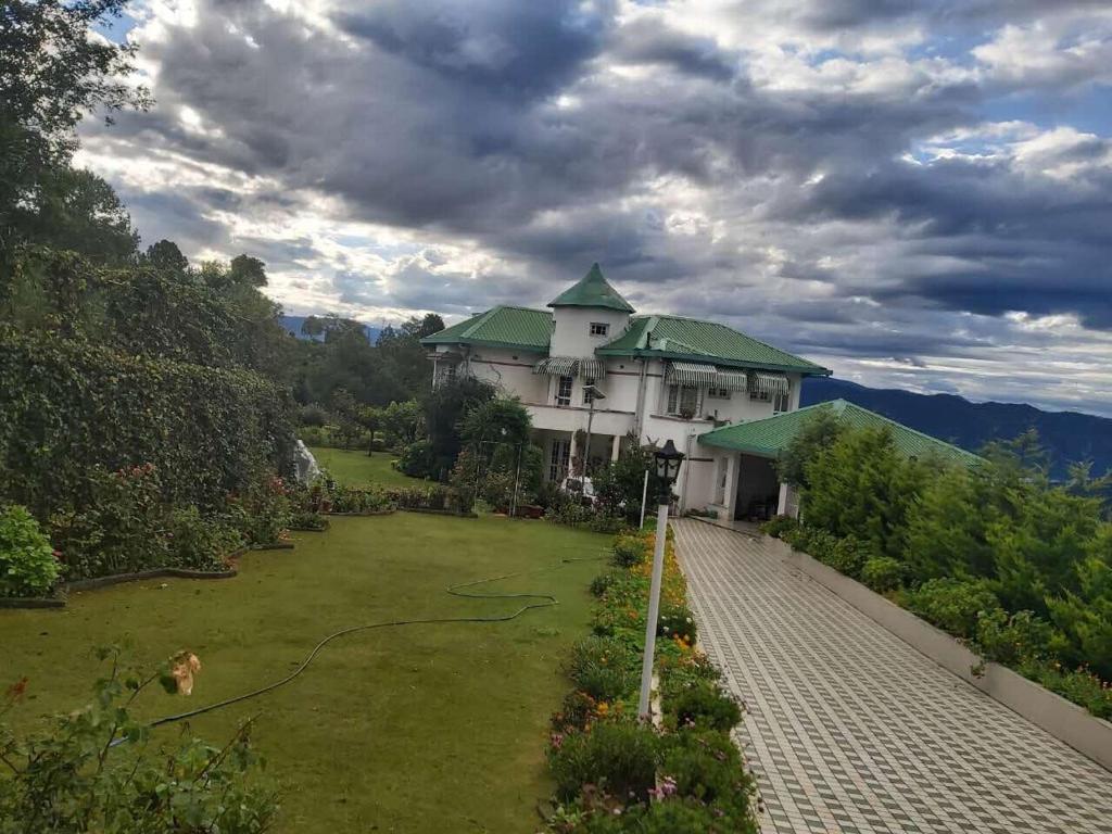 a large house with a green roof and a garden at Rosewood Estate in Chail
