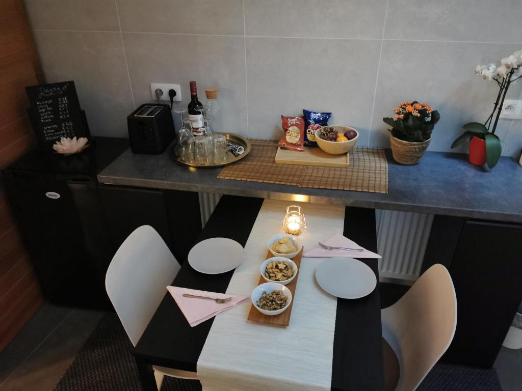 una cocina con una mesa con tazones de comida. en Mica beauty & wellness center, en Temse