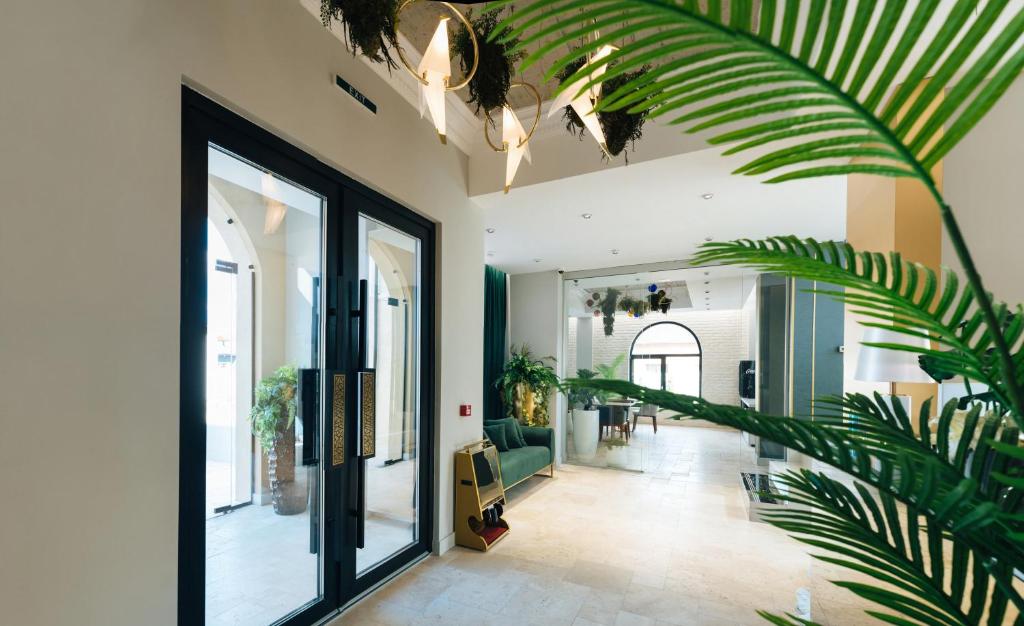a hallway with a large glass door and a plant at ARN Boutique Hotel in Focşani