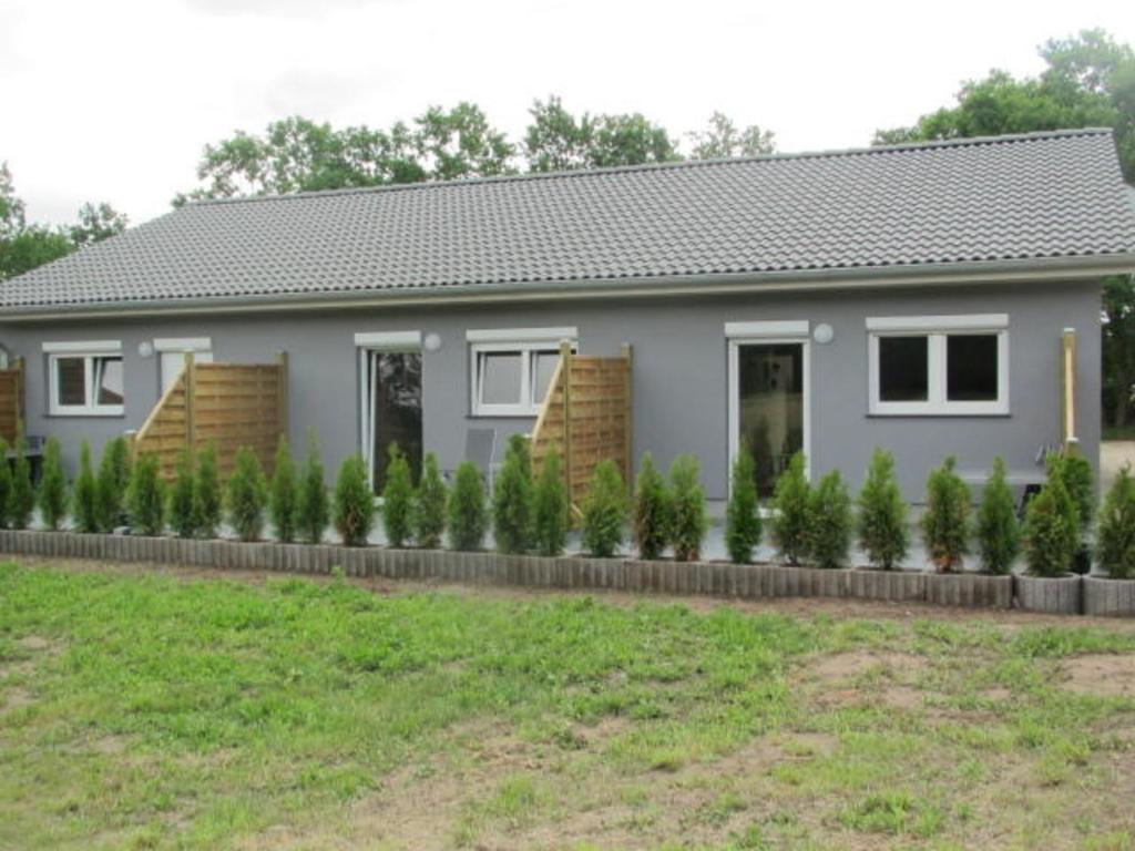 a house with a row of plants in front of it at Barons Ferienappartement B in Dargun