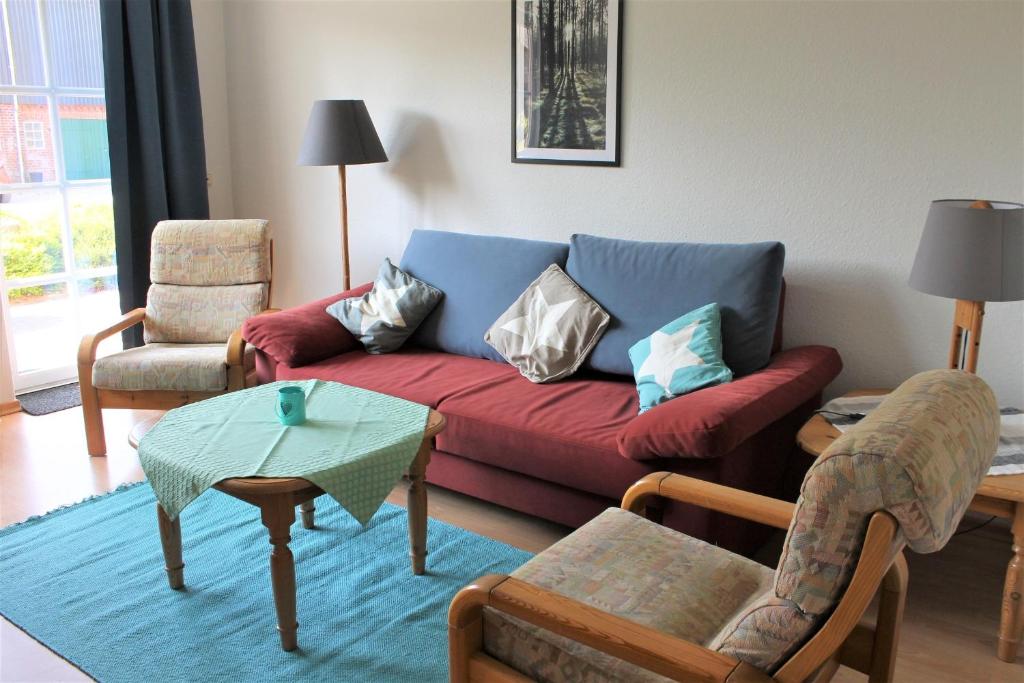 グレーミッツにある"Pappelhof - Whg 2"のリビングルーム(赤いソファ、椅子付)