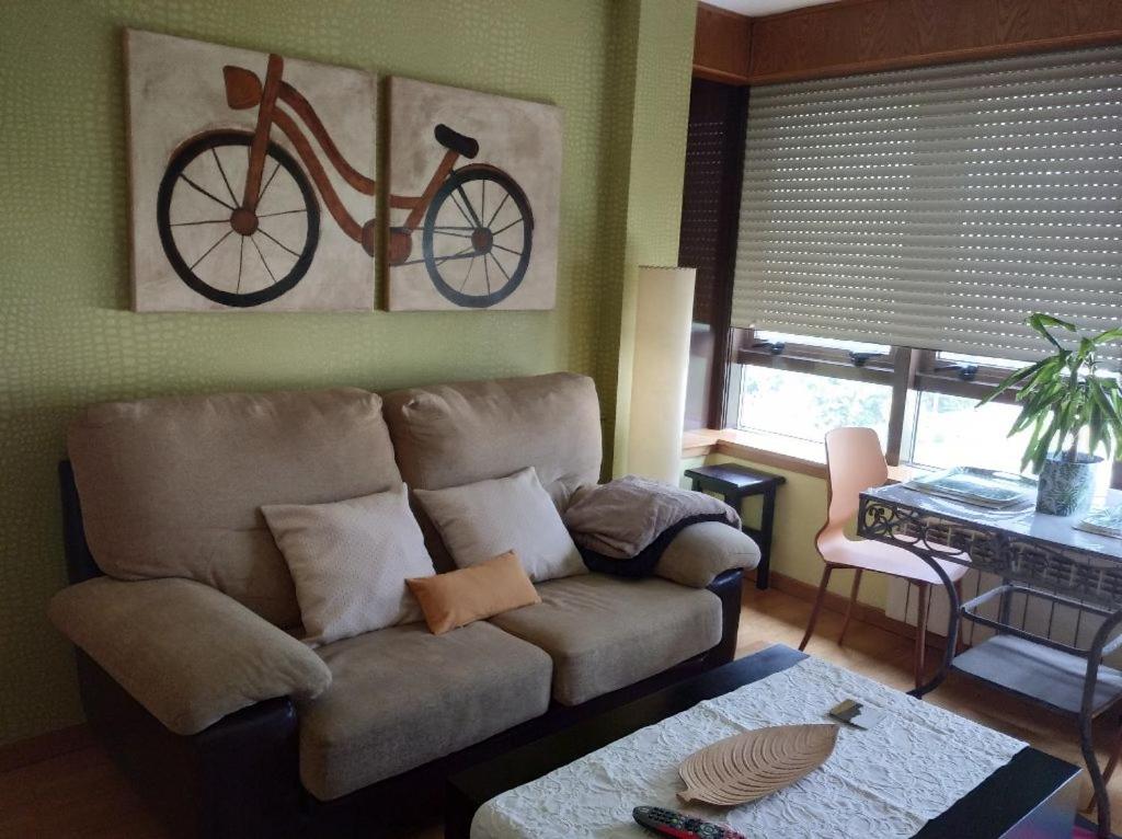 ein Wohnzimmer mit Sofa und Fahrrad an der Wand in der Unterkunft María Belkis ll in Ourense