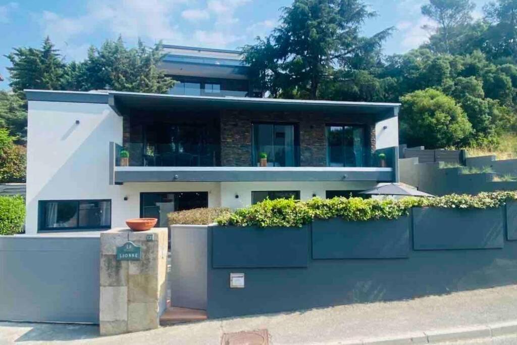 une grande maison blanche avec des plantes dans l'établissement Haut de villa de charme - 3 chambres 6pers, à Saint-Raphaël