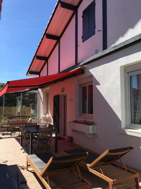 un patio avec des chaises et une table et un bâtiment dans l'établissement Mimizan Plage Grande maison bord de mer, à Mimizan