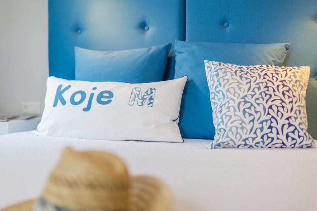 a bed with a blue headboard and a hat on it at Whg 01 - Koje M in Zingst