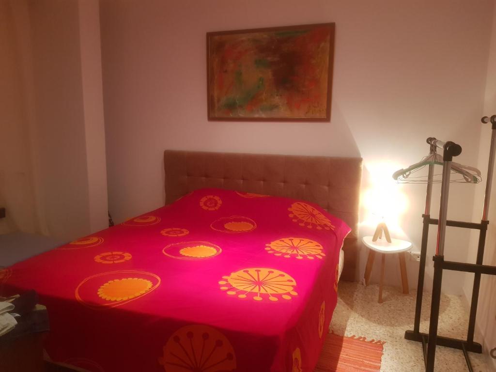 a red bed in a room with a lamp at Appartement Ain Zaghouan in Tunis