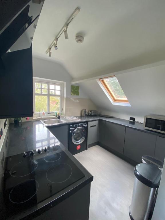 a kitchen with a sink and a stove in it at Pristine 2 bedroom apartment with off street parking in Norwich