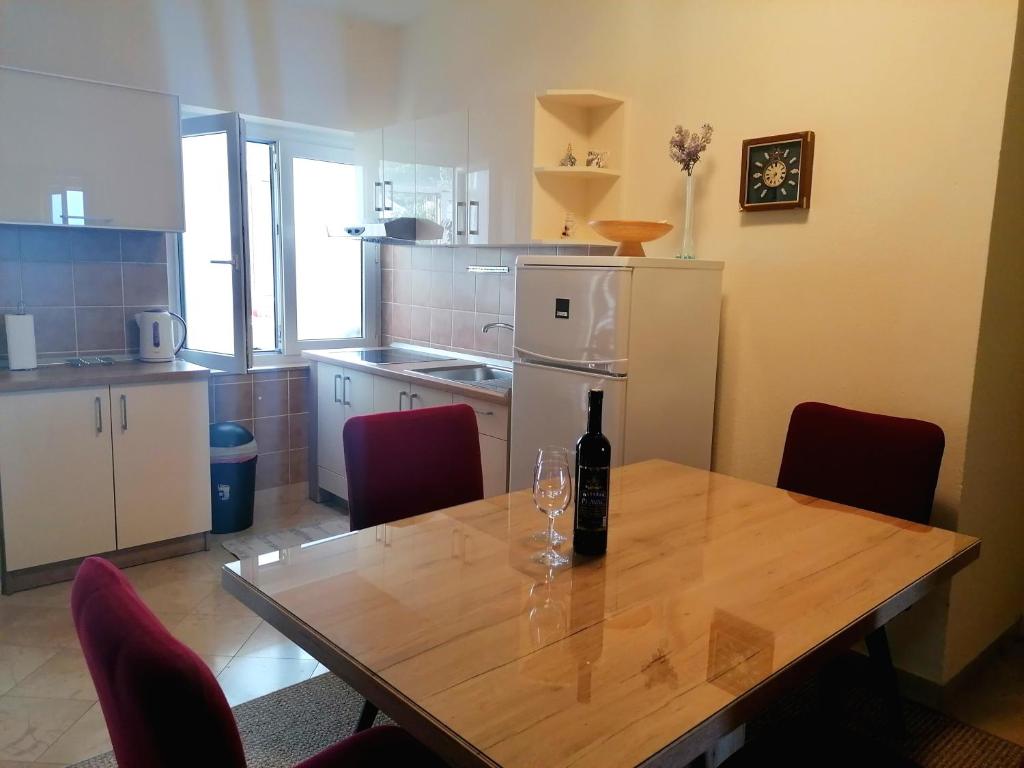 una cocina con una mesa con una botella de vino. en Apartments Melinda, en Baška Voda