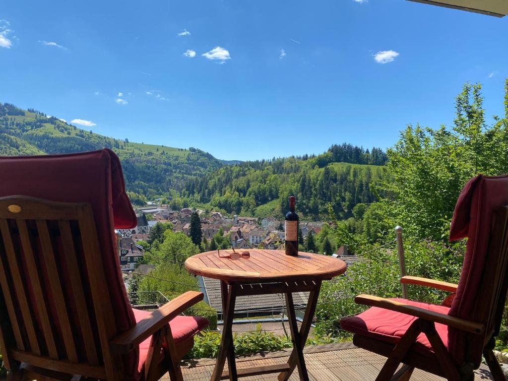 uma garrafa de vinho sentada numa mesa num pátio em Ferienwohnung Traumblick em Schönau im Schwarzwald