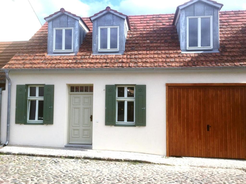 uma casa branca com janelas verdes e uma garagem de madeira em Michaelishaus em Werder