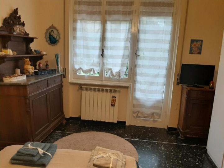Zimmer mit 2 Fenstern, einem Tisch und einem TV in der Unterkunft La Tana Dei Conigli in Serra Rocco