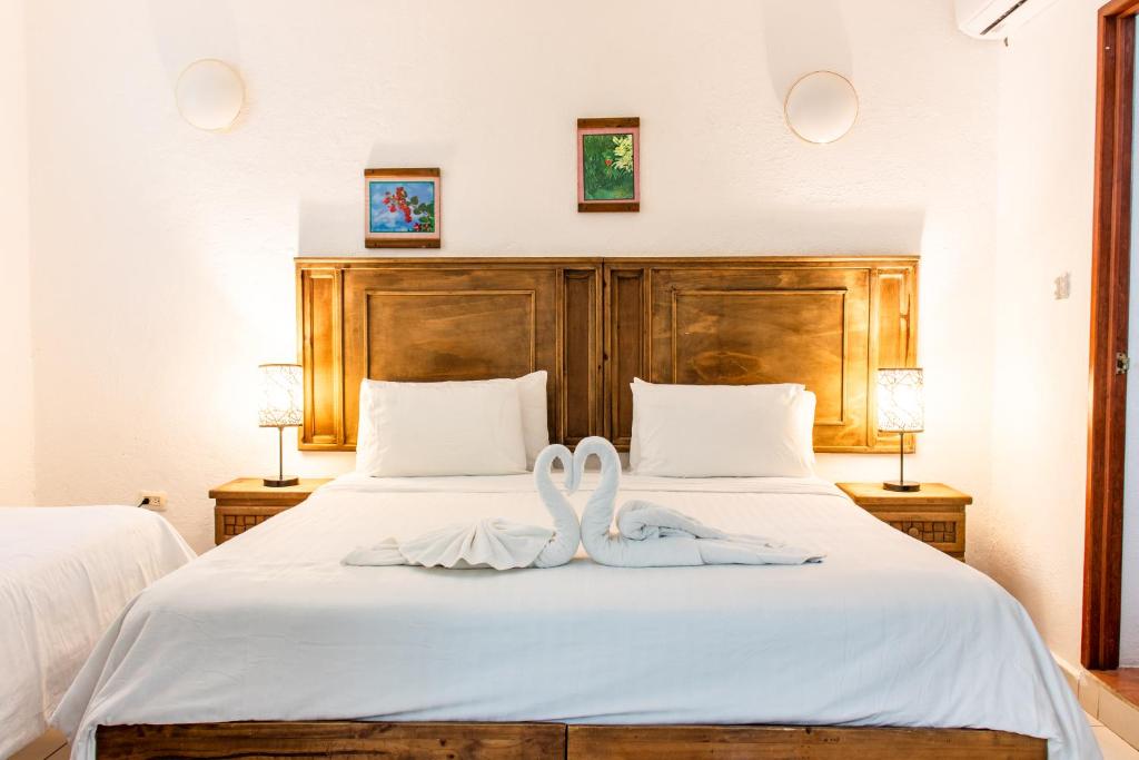 Zwei weiße Handtücher liegen auf einem Bett. in der Unterkunft Apart Hotel Casaejido in Playa del Carmen