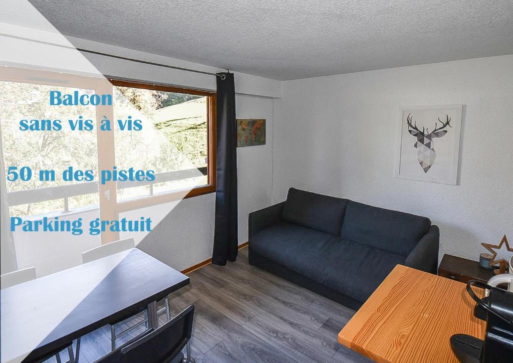 a living room with a couch and a table at Les Cimes, Chaleureux studio 4 pers, 50m du télécabine, vue dégagée sur les pistes, DRAPS NON COMPRIS in Saint-Jean-d'Aulps