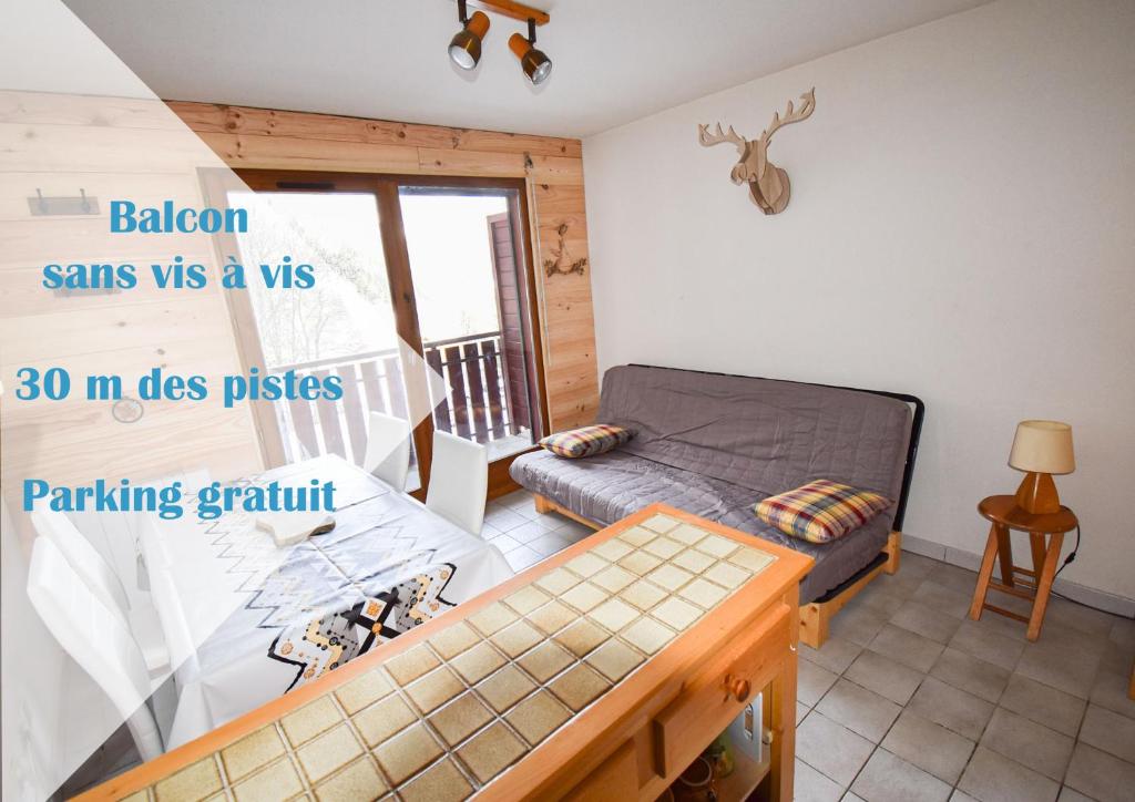 a bedroom with a bed and a table in a room at Le Pied des Pistes A13, Joli Studio tout confort 4 pers, vue vallée imprenable, DRAPS NON COMPRIS in Saint-Jean-d'Aulps