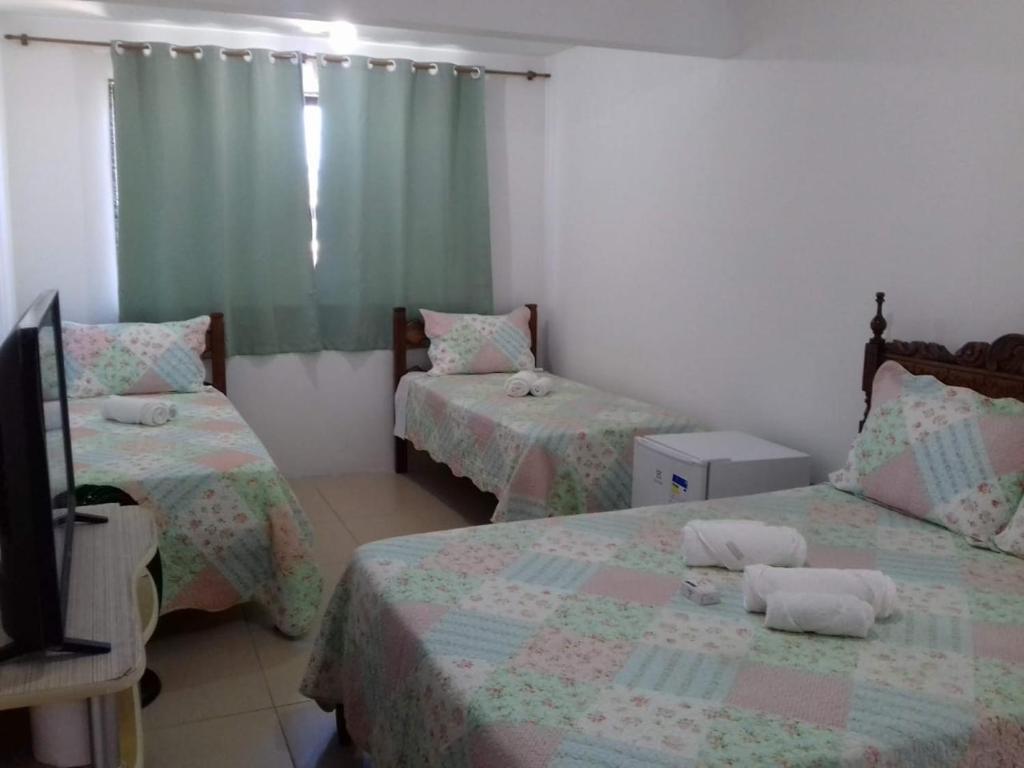 Giường trong phòng chung tại Quartos Praia do Foguete Cabo Frio